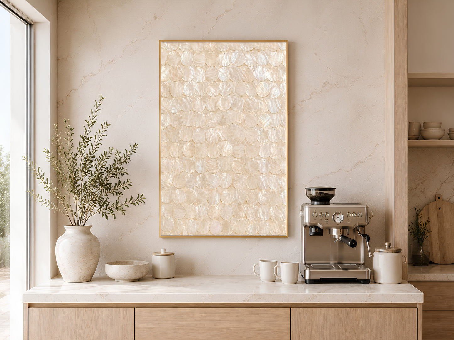 Capiz shell wall art print in a gold frame displayed above a light wood sideboard in a modern kitchen with neutral tones, pendant light, and warm natural light
