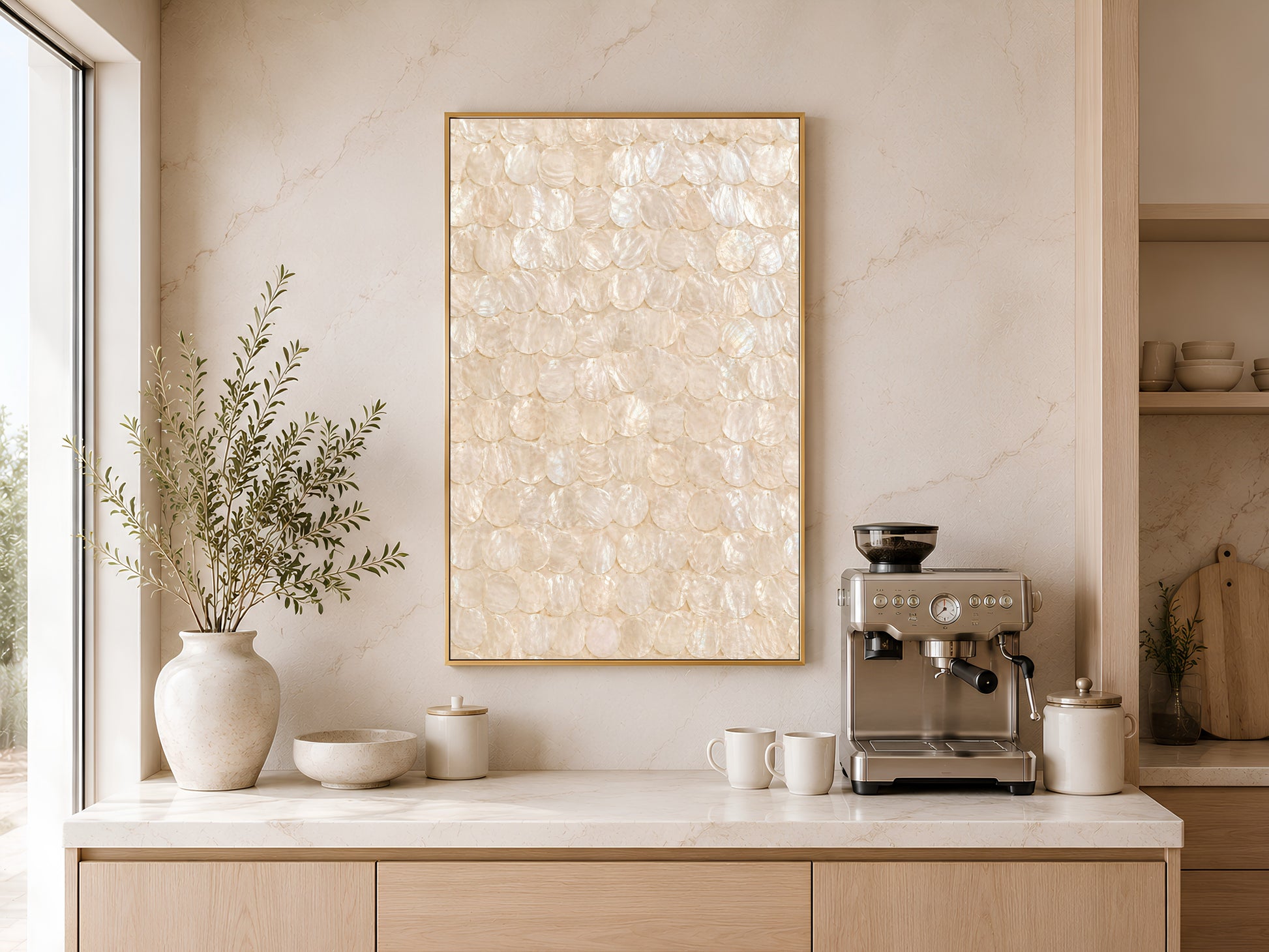 Capiz shell wall art print in a gold frame displayed above a light wood sideboard in a modern kitchen with neutral tones, pendant light, and warm natural light
