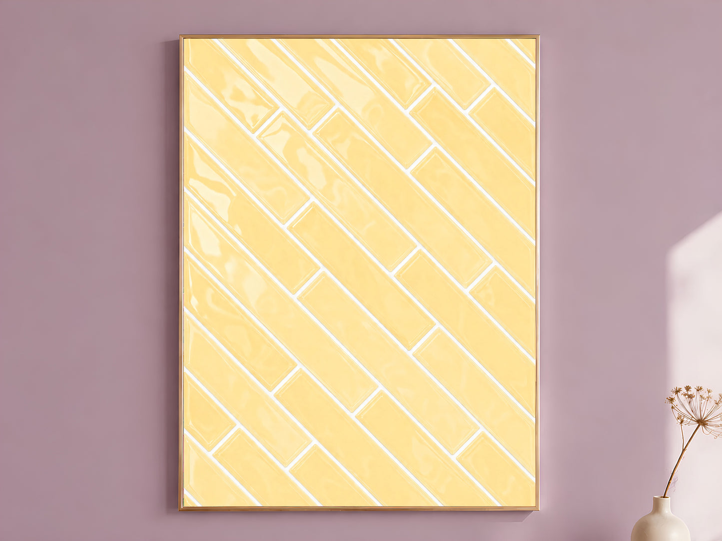 Butter yellow glossy herringbone tile art print in a natural wood frame displayed against a dusty mauve wall with a dried floral stem in soft shadow light