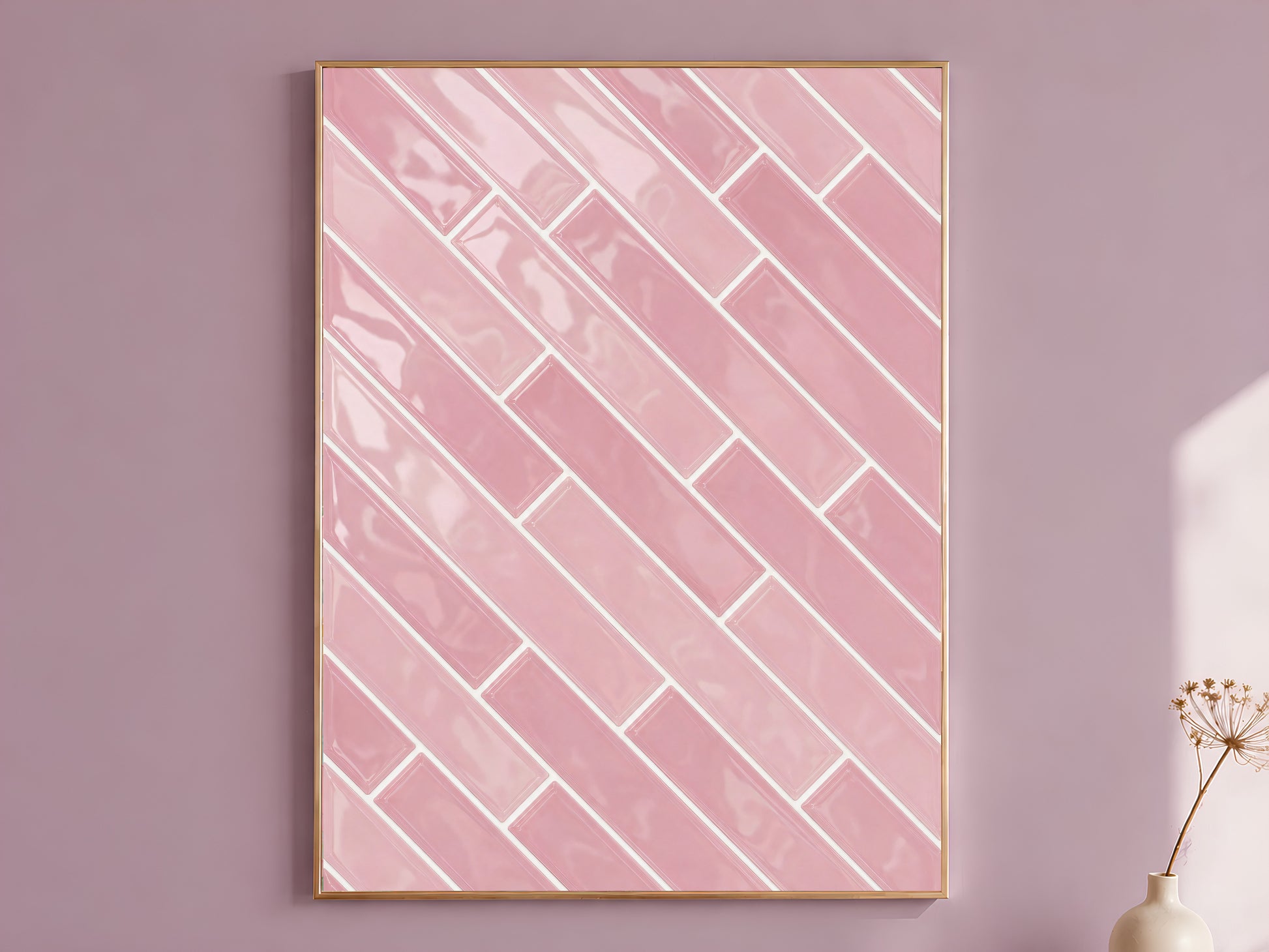 Pink herringbone tile wall art print in a gold frame on a soft mauve wall with a dried flower stem beside it, showing full glossy blush ceramic tile pattern with white grout lines
