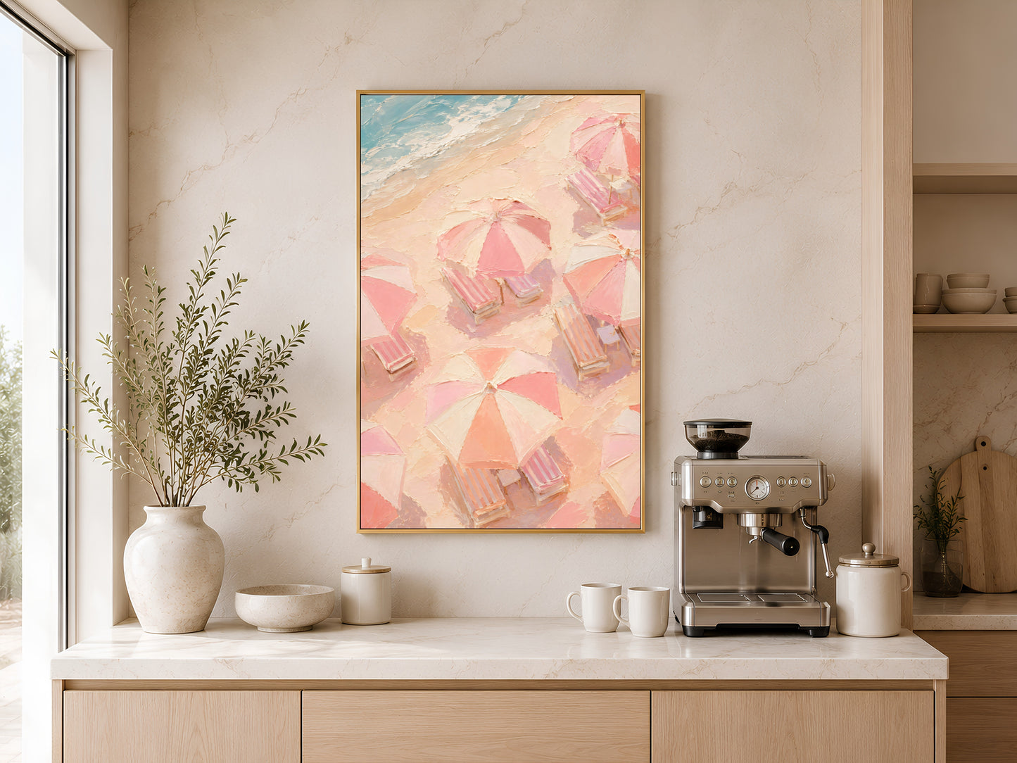 Pastel beach chair and umbrella print in gold frame above a wooden sideboard with coffee machine in a neutral kitchen