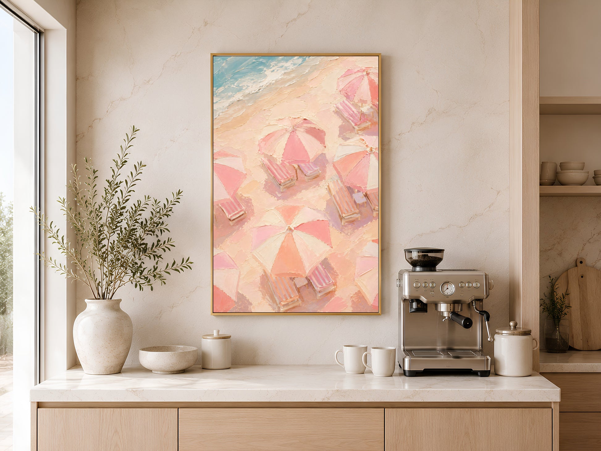 Pastel beach chair and umbrella print in gold frame above a wooden sideboard with coffee machine in a neutral kitchen