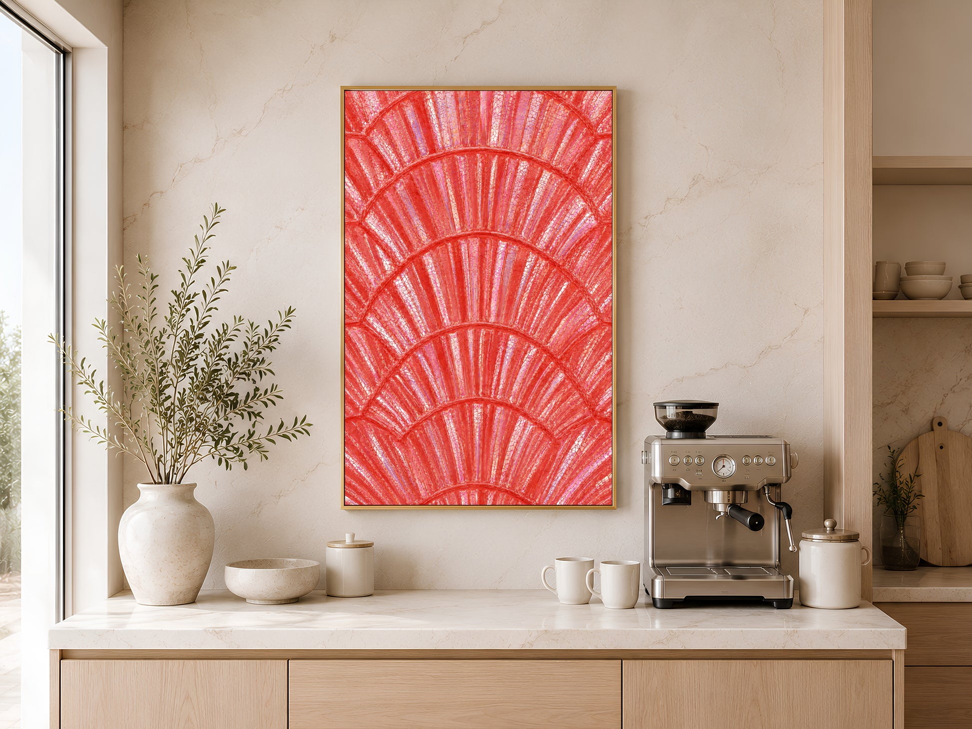 Coral capiz shell print in gold frame above a wooden sideboard with coffee machine in a warm neutral kitchen