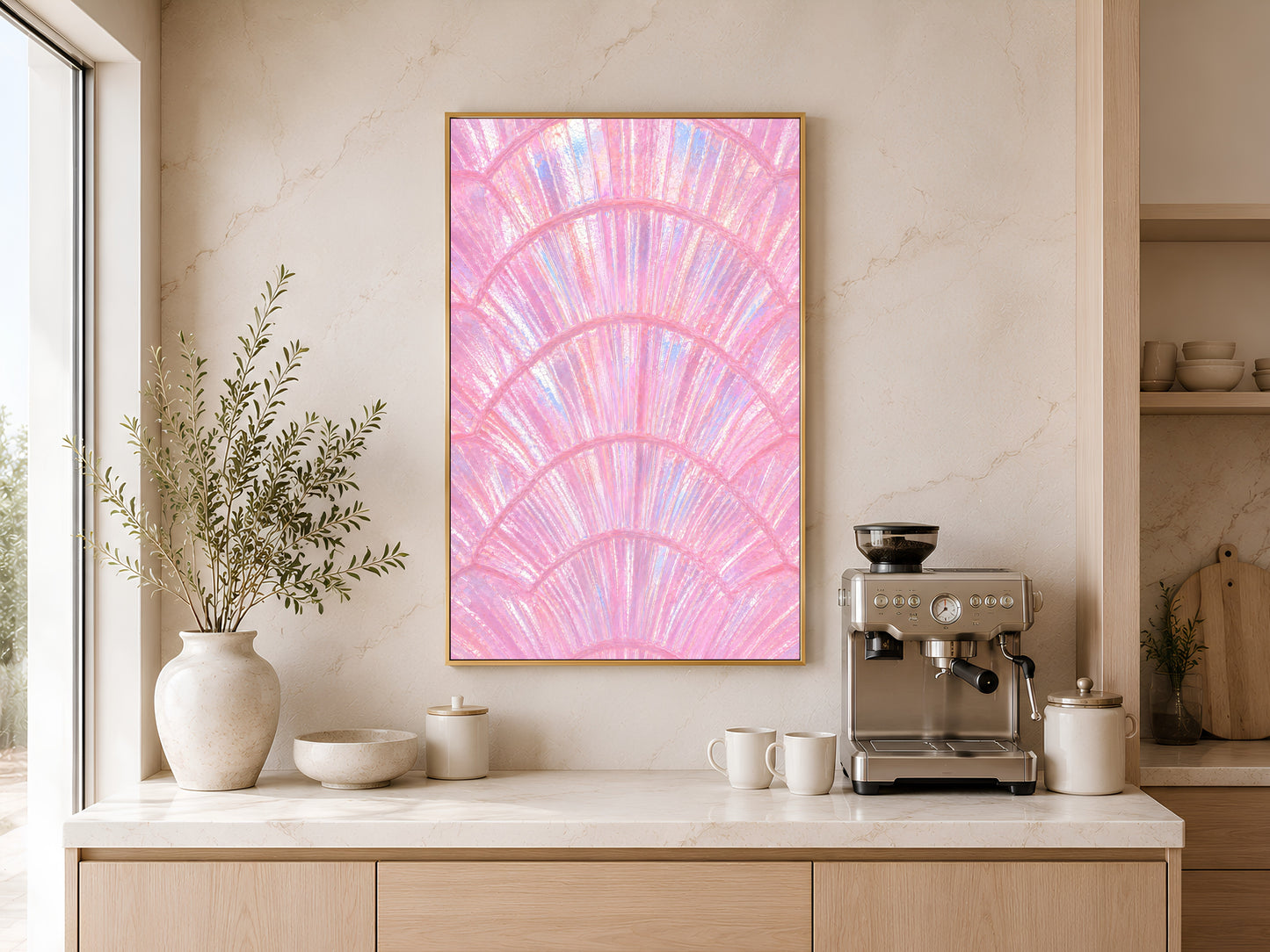 Pink capiz shell coastal art in gold frame above a wooden sideboard with coffee machine in a warm neutral kitchen