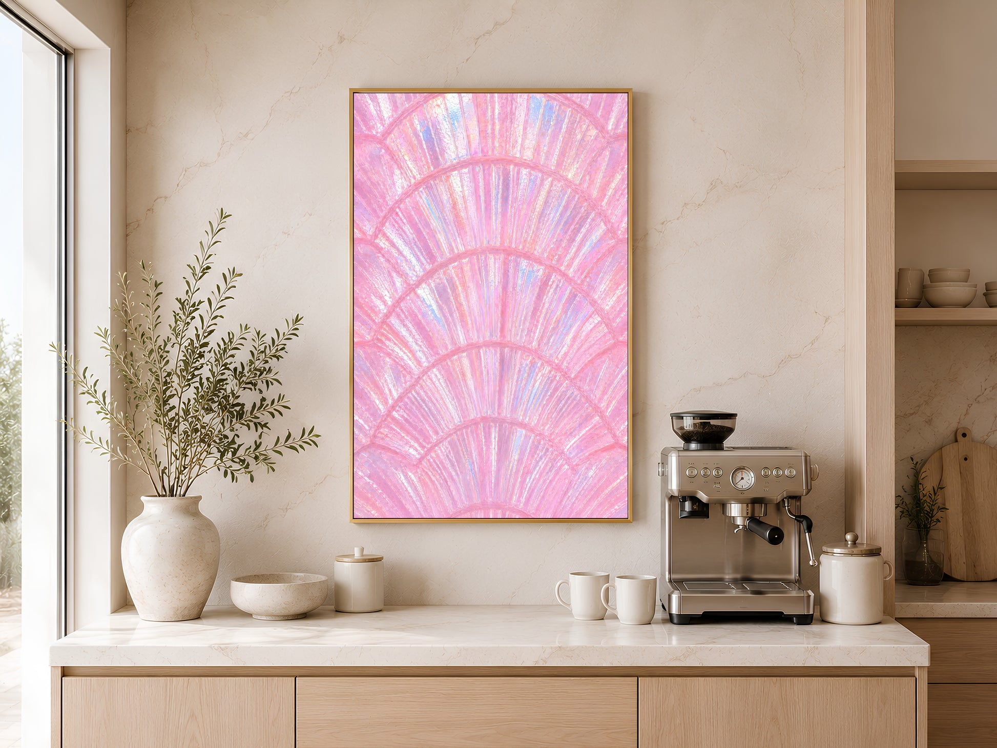 Pink capiz shell coastal art in gold frame above a wooden sideboard with coffee machine in a warm neutral kitchen