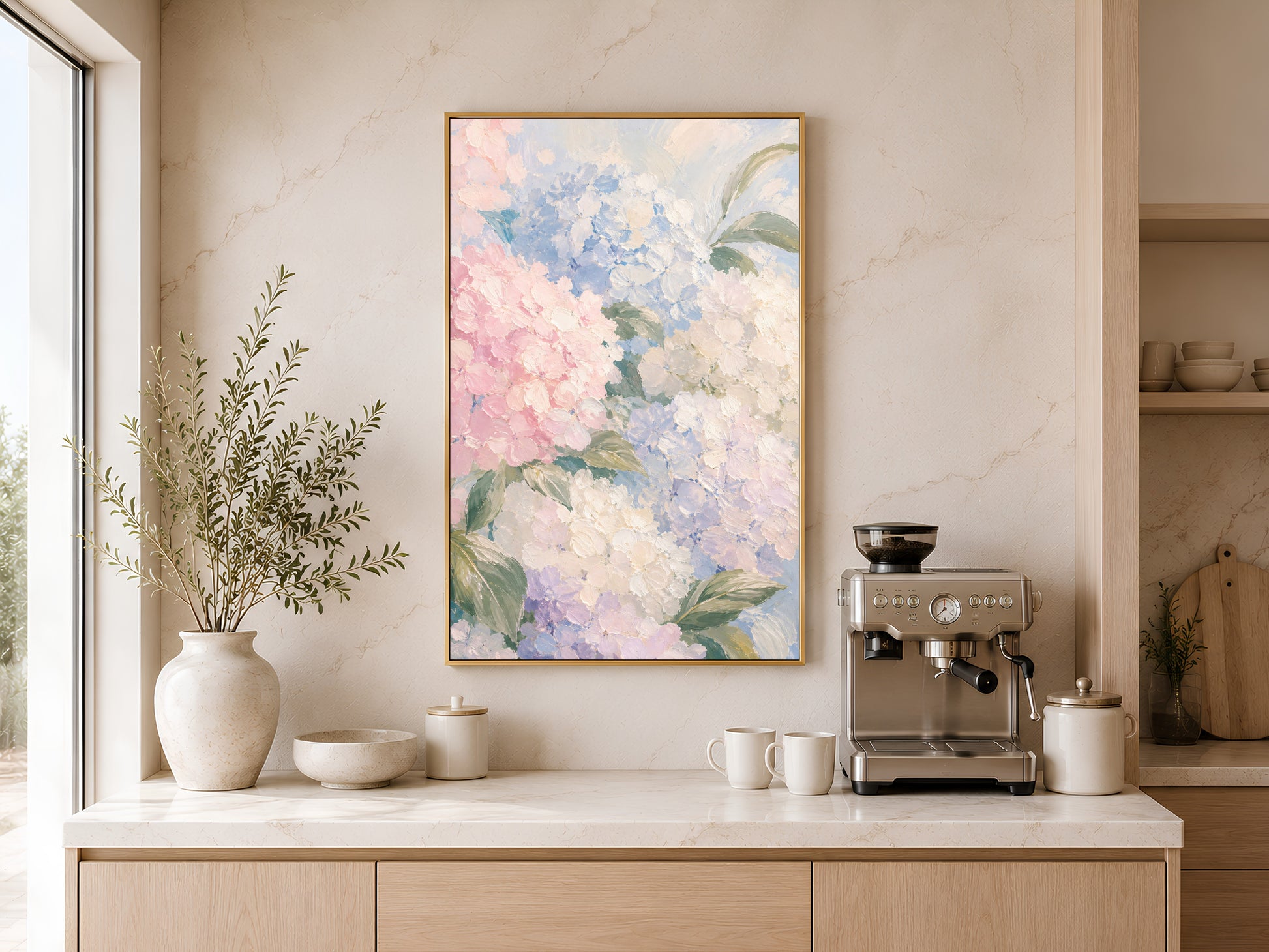 
Pink and blue hydrangea wall art in gold frame above a wooden sideboard with coffee machine in a warm neutral kitchen