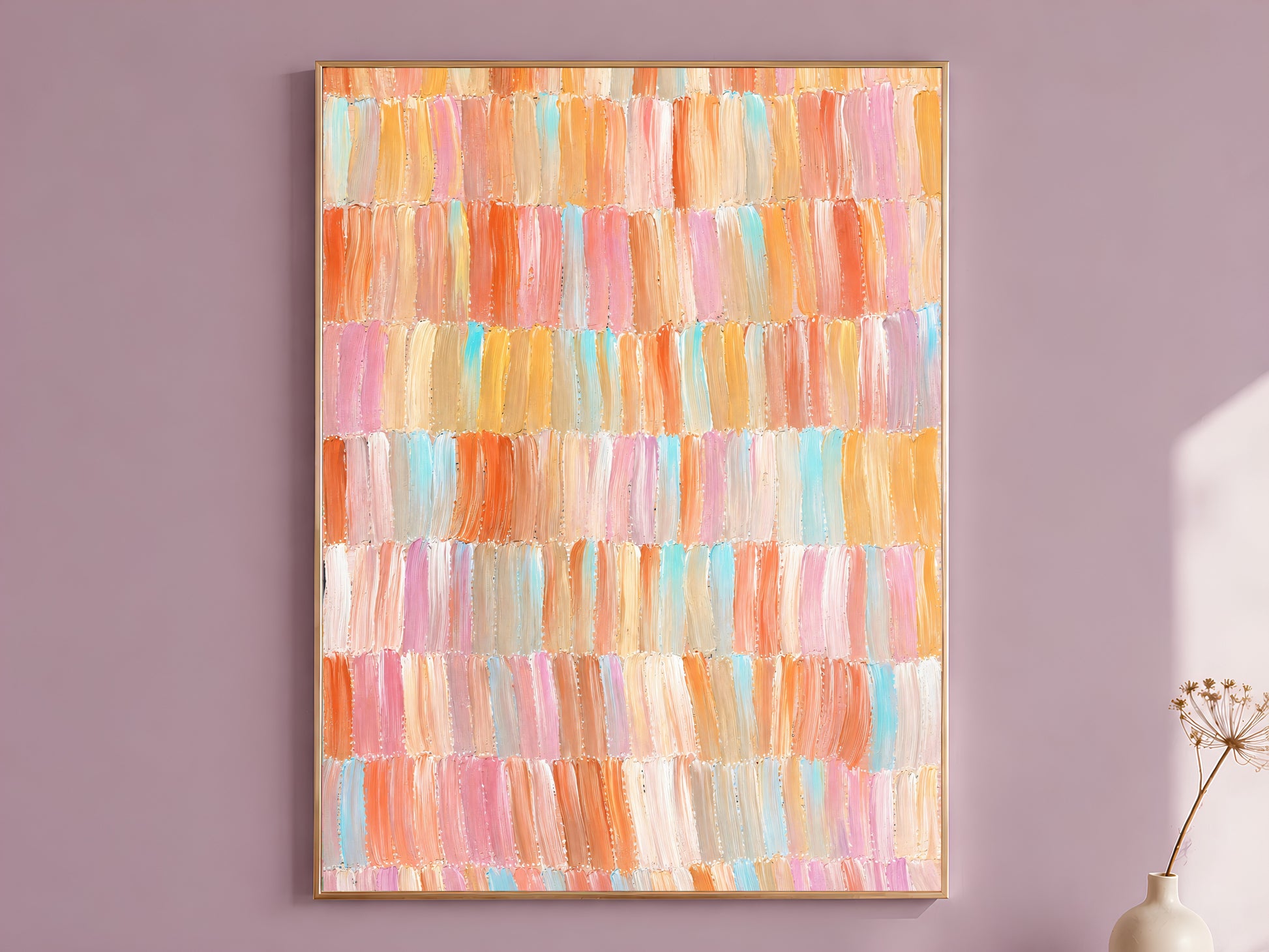 Colorful brushstroke mosaic wall art print in a wood frame displayed on a dusty mauve wall with dried florals