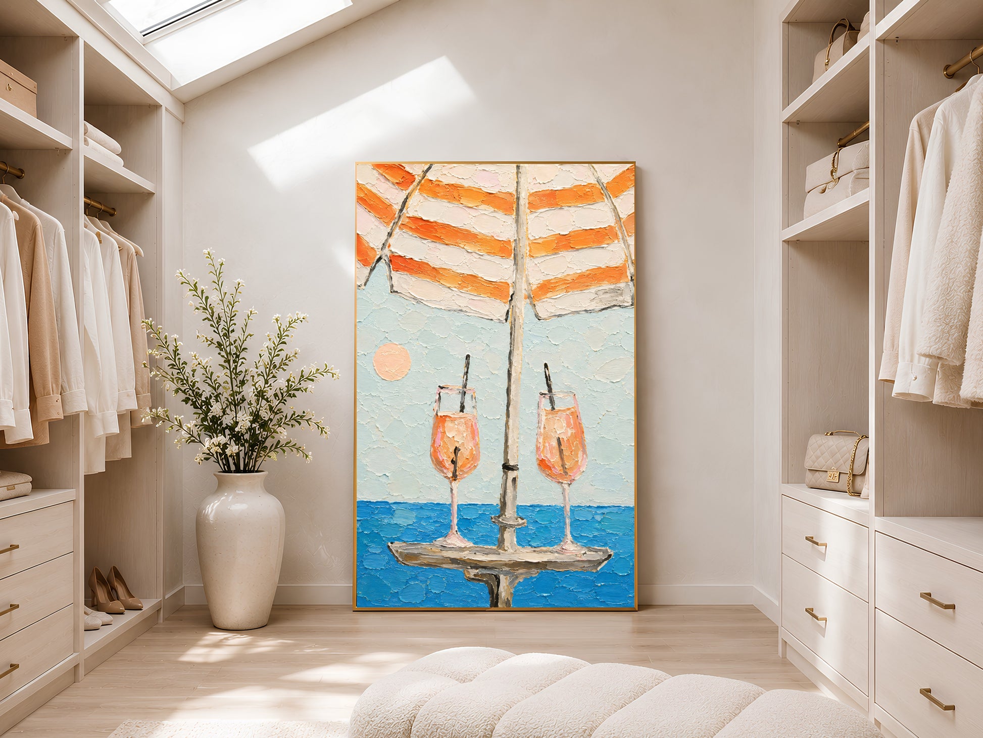 Framed orange stripe beach umbrella cocktail wall art leaning in a bright walk-in wardrobe with skylight, white cabinetry, and large ceramic floor vase
