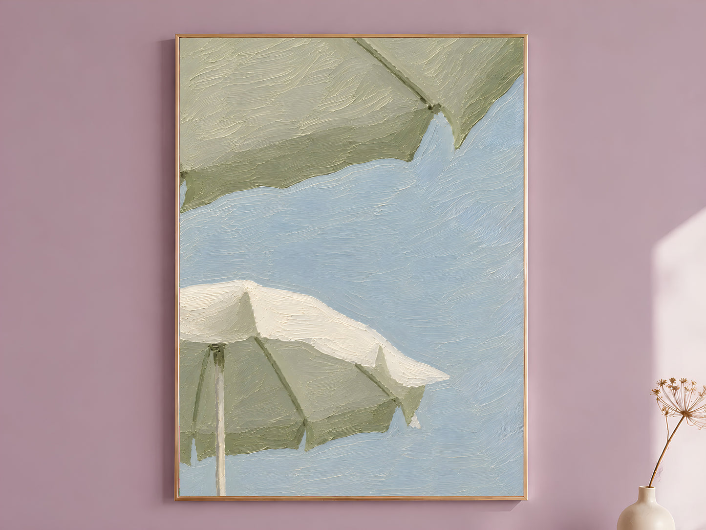 Impasto oil painting style sage green beach umbrella wall art print in a thin gold frame displayed against a dusty mauve wall, showing two oversized sage and cream umbrellas against a powder blue sky