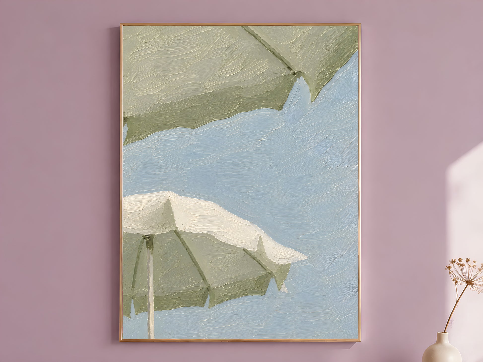 Impasto oil painting style sage green beach umbrella wall art print in a thin gold frame displayed against a dusty mauve wall, showing two oversized sage and cream umbrellas against a powder blue sky