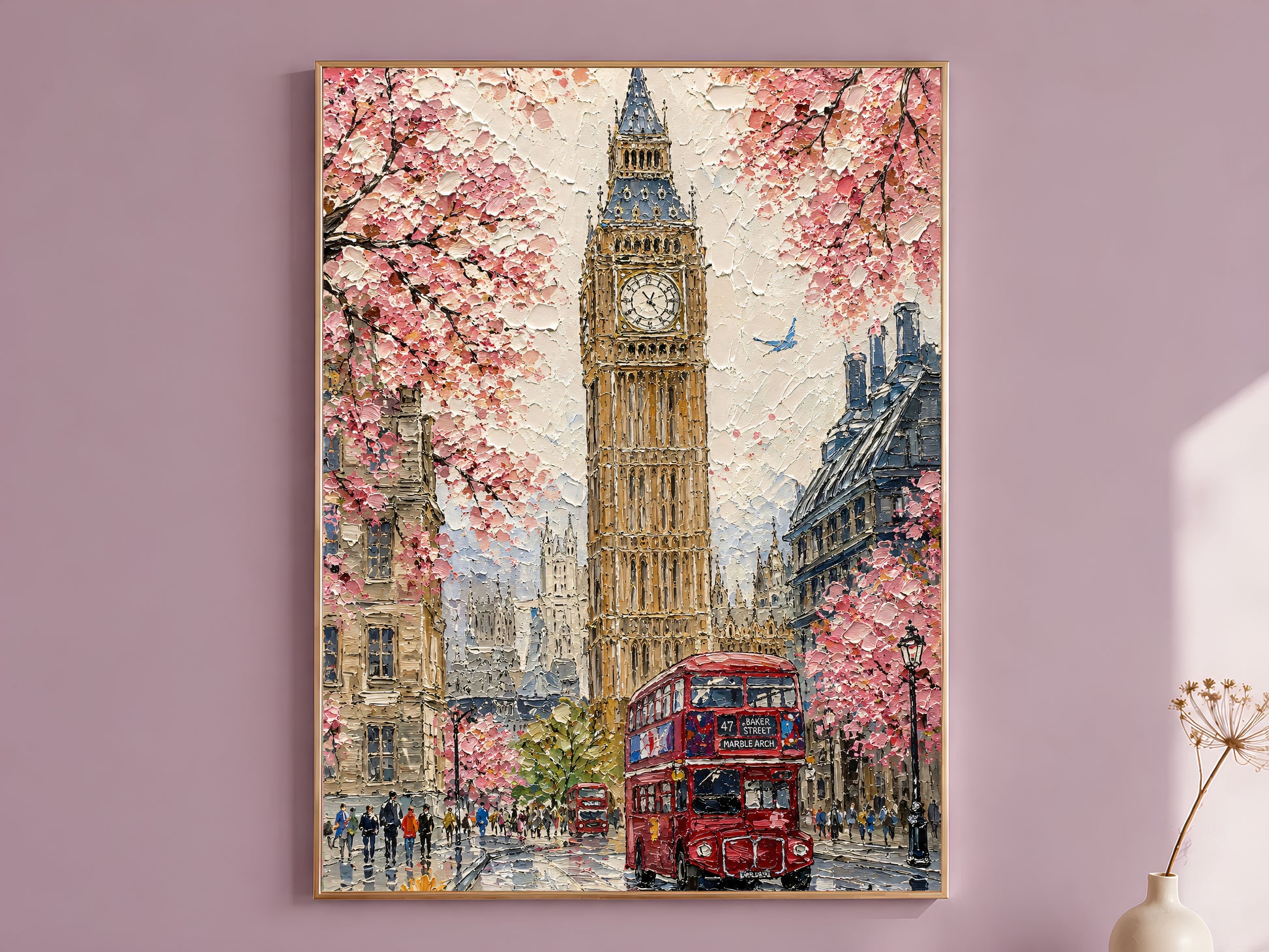 Impasto oil painting style London wall art print in a thin gold frame displayed against a dusty mauve wall, showing Big Ben rising through pink cherry blossom trees with a red double-decker bus on a rain-wet street and tiny figures below