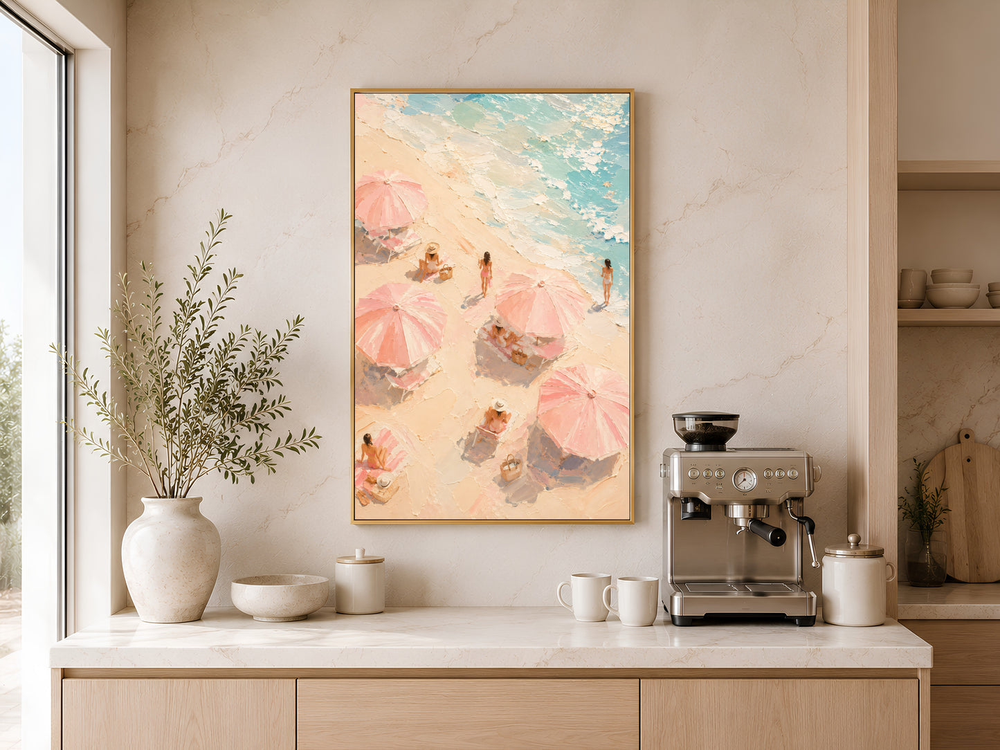 Beach umbrella aerial print in gold frame above a wooden sideboard with coffee machine in a warm neutral kitchen