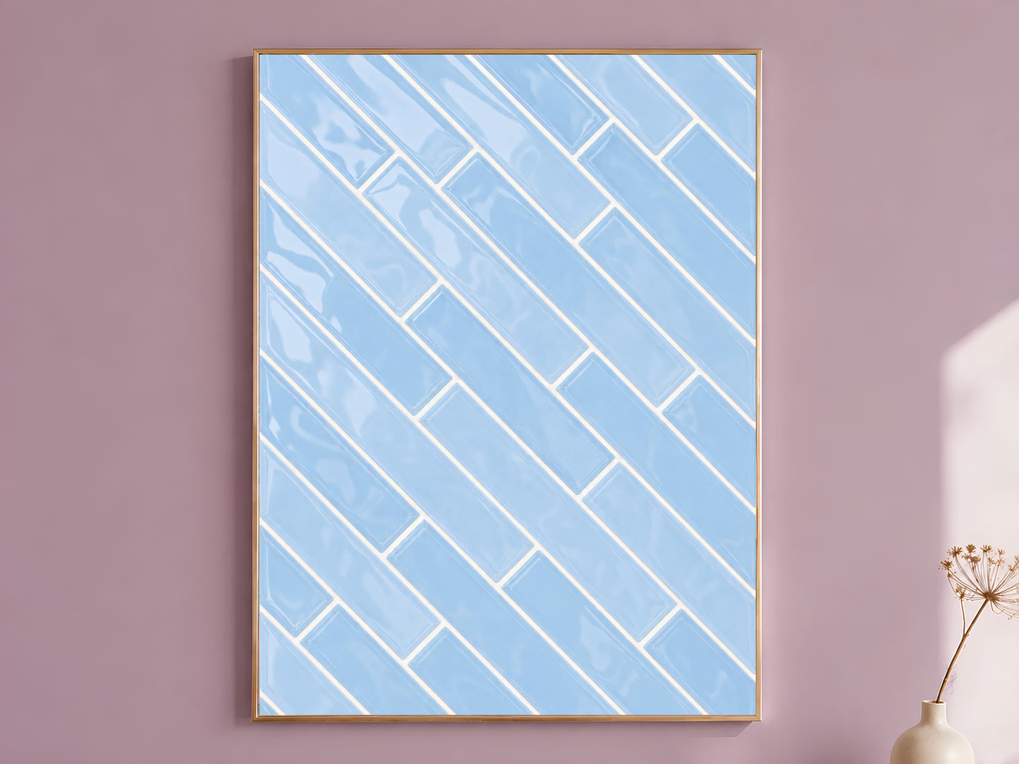 Blue herringbone tile wall art print in a gold frame on a soft mauve wall with a dried flower stem beside it, showing full glossy powder blue ceramic tile pattern with white grout lines
