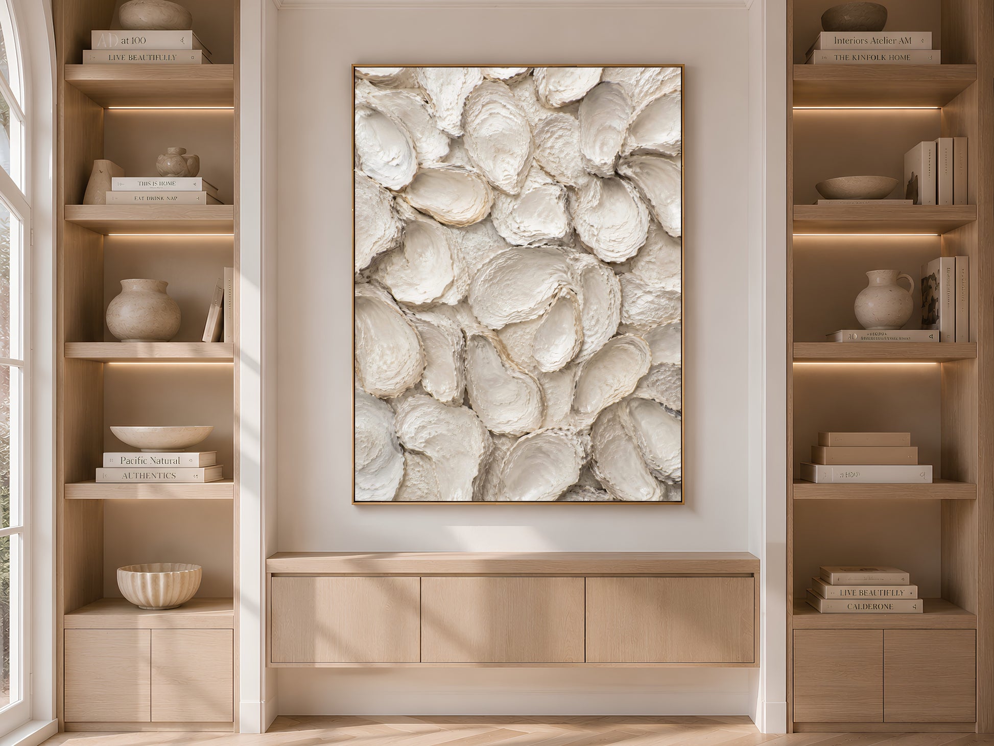 Built-in bookshelf niche with styled decor and a framed oyster shell print centered between the shelving.
