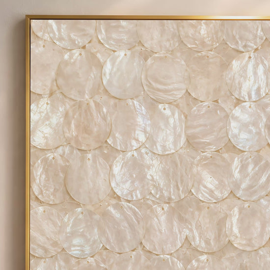 Capiz shell wall art video mockup thumbnail showing a close-up of the overlapping iridescent ivory and cream shell disc pattern in a gold frame against a warm neutral interior
