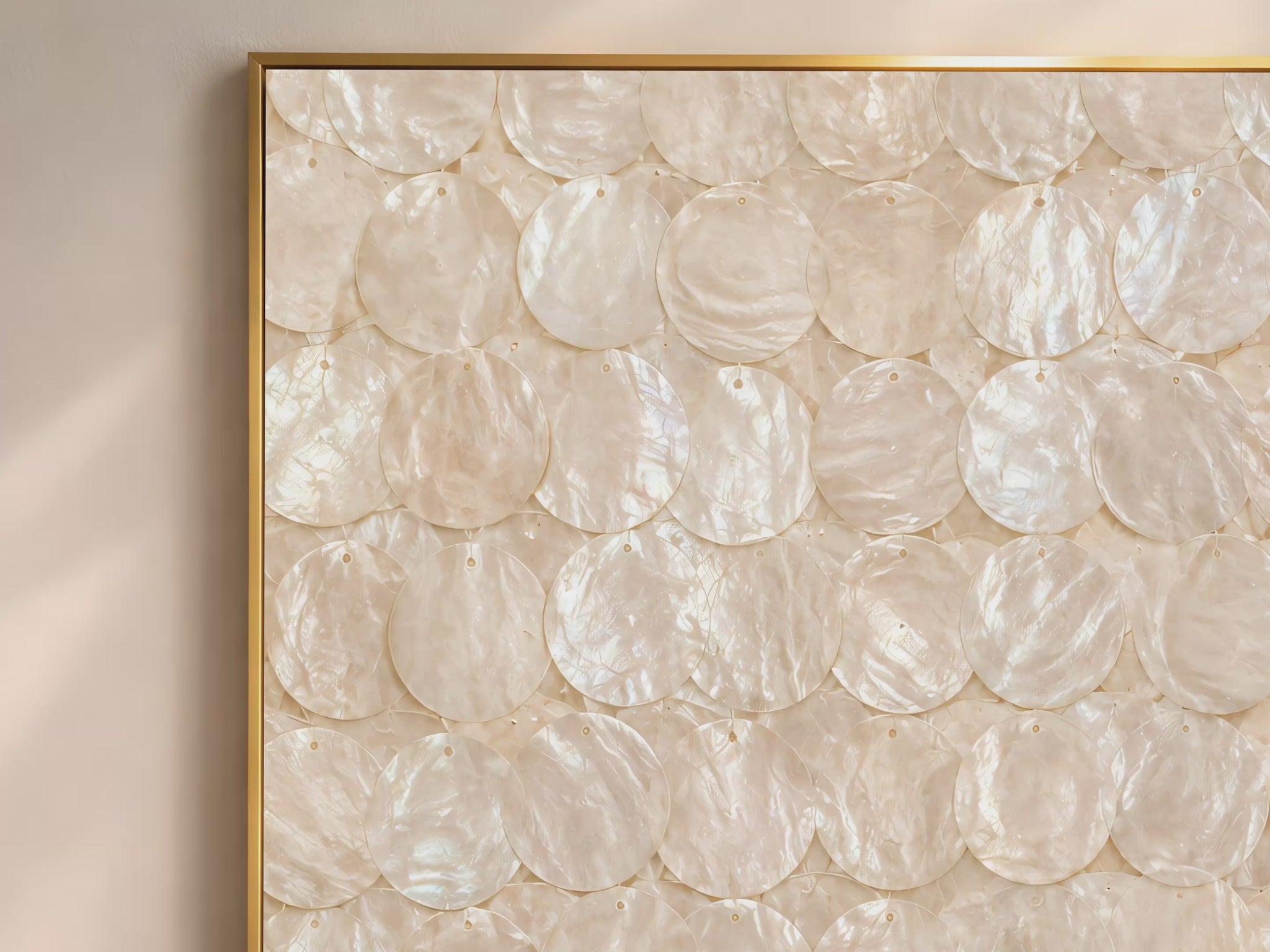 Capiz shell wall art video mockup thumbnail showing a close-up of the overlapping iridescent ivory and cream shell disc pattern in a gold frame against a warm neutral interior
