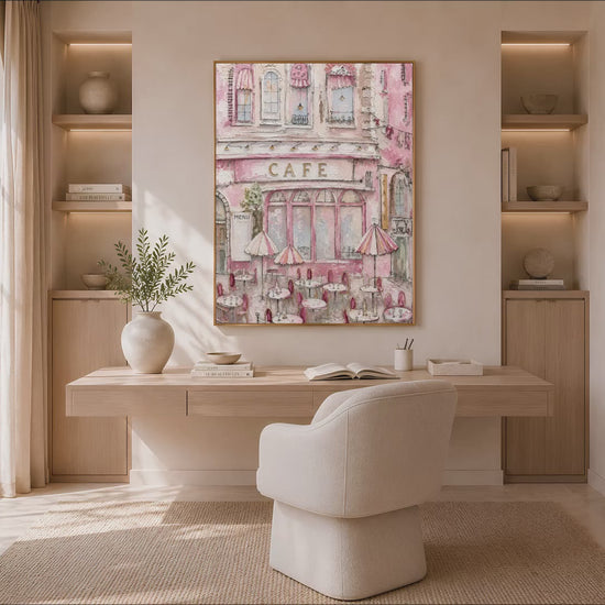 Parisian pink cafe wall art in a gold frame above a living room with an arched alcove and a boucle armchair
