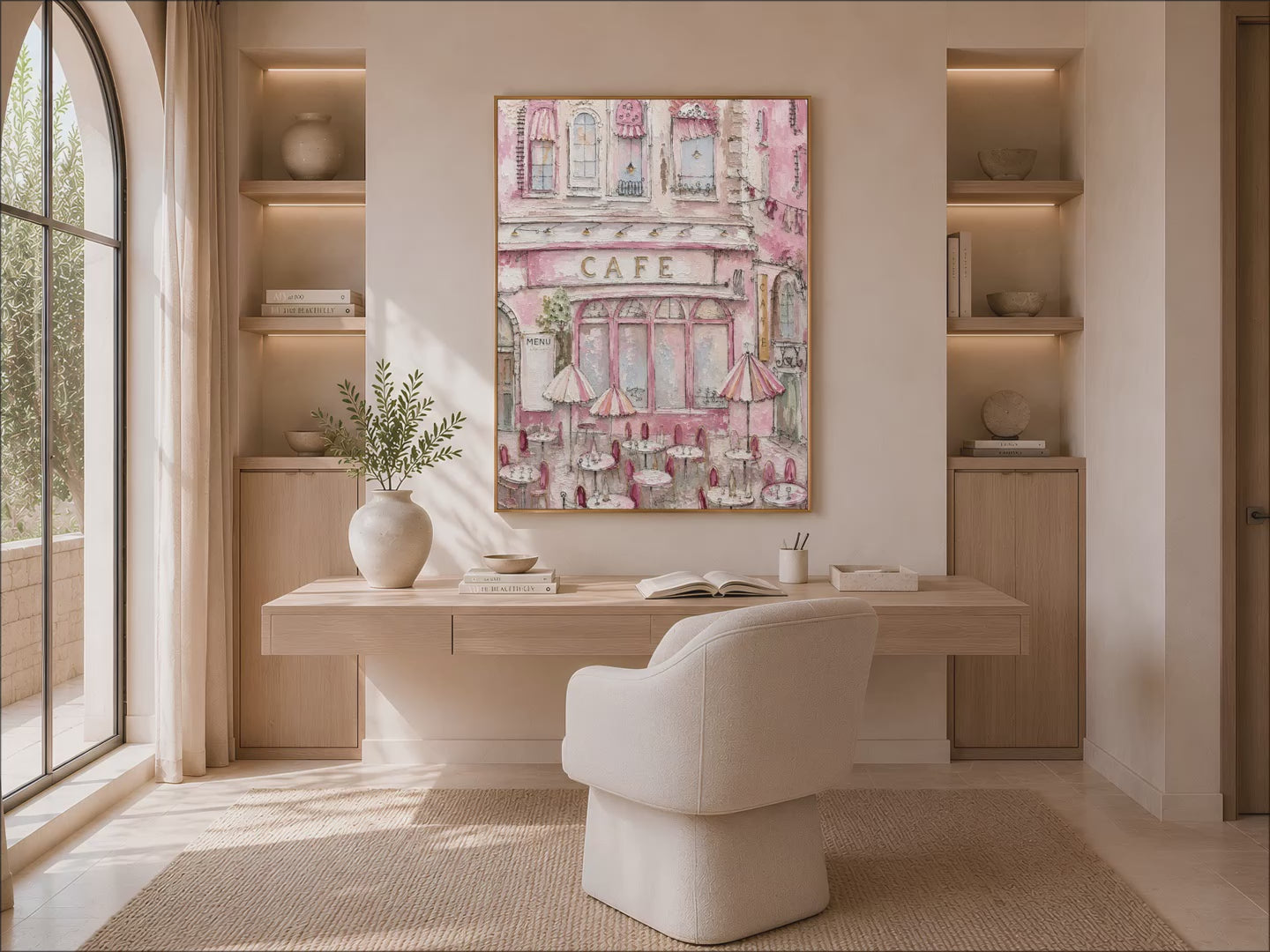 Parisian pink cafe wall art in a gold frame above a living room with an arched alcove and a boucle armchair