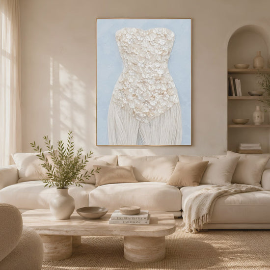 Framed mother of pearl textural art print styled above a cream boucle sofa in a bright neutral living room.