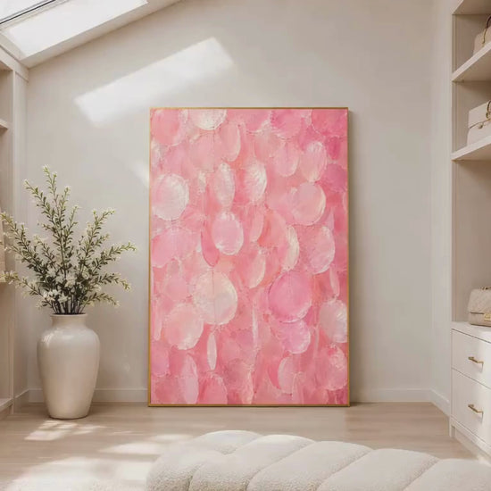 Pink capiz shell wall art print in a gold frame inside a bright walk-in closet with white shelving, a potted plant, and soft neutral flooring
