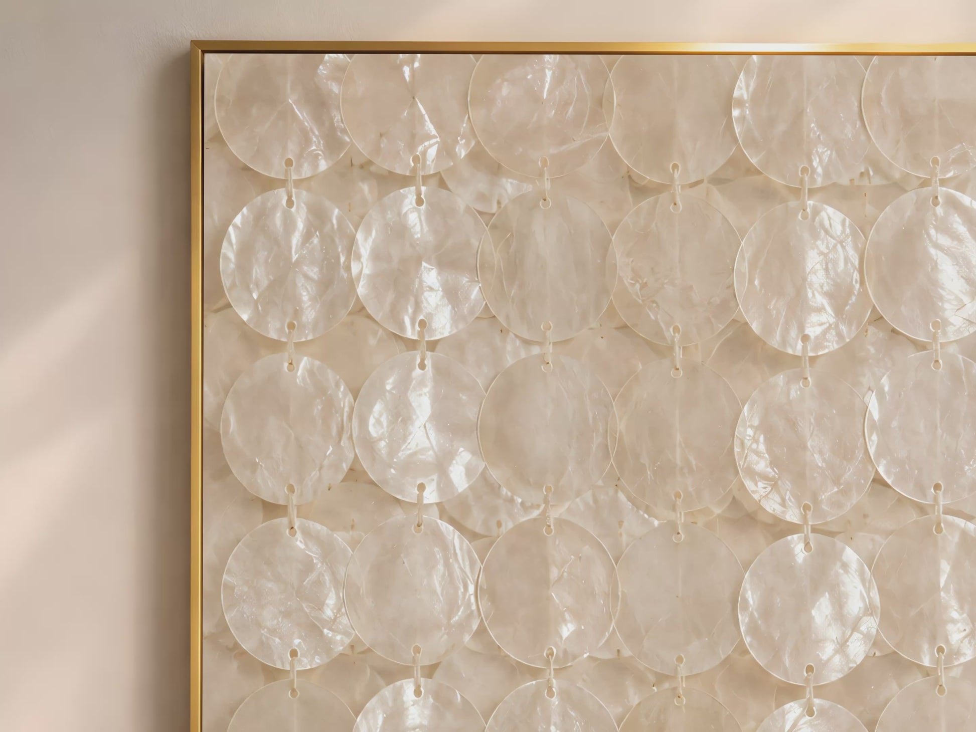 Capiz shell wall art video mockup thumbnail showing the full pattern of translucent ivory shell discs strung in vertical rows in a gold frame against a warm neutral interior wall
